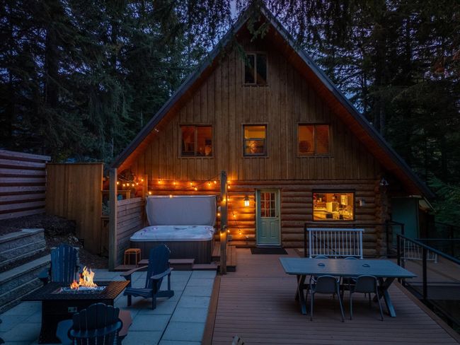 Rear view of property with fence, a fire pit, a deck, and a covered hot tub | Image 5