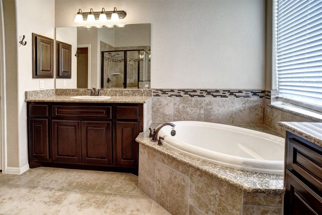 Main bath with dual vanities, garden tub, and separate shower | Image 18