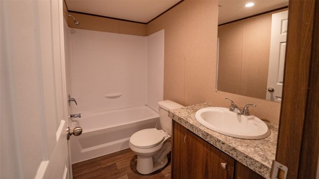 Full bathroom featuring wood finished floors, vanity, shower / washtub combination, and crown molding | Image 18