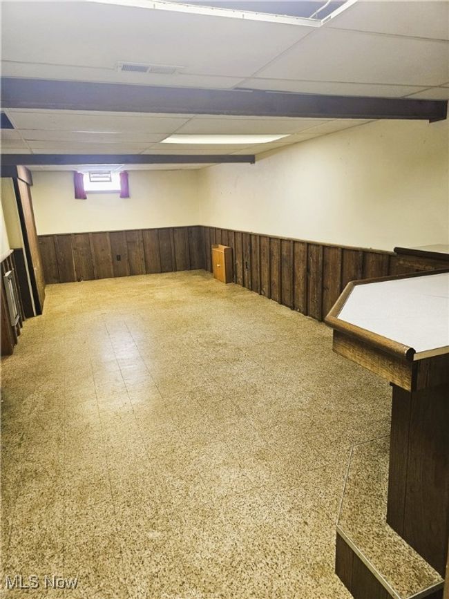 Below grade area featuring a wainscoted wall, a drop ceiling, and wooden walls | Image 10