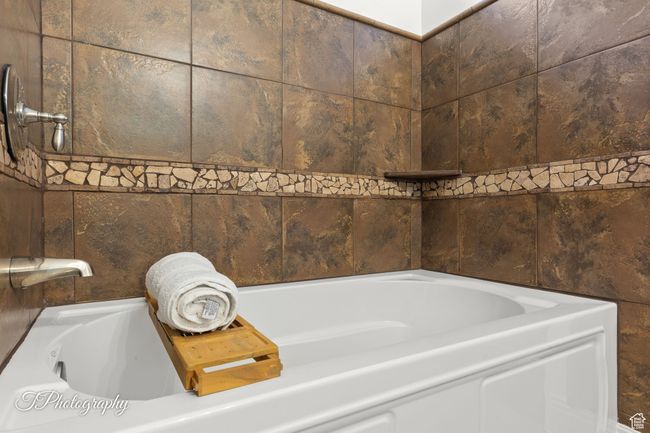 Full bathroom featuring a garden tub | Image 73
