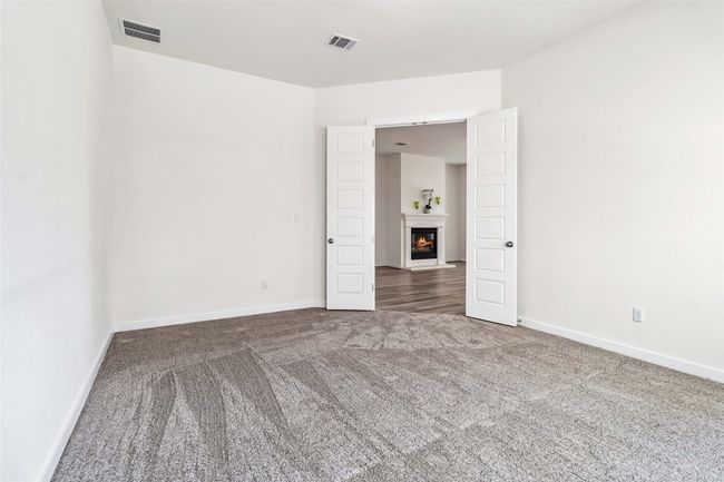 Empty room with carpet and a warm lit fireplace | Image 22