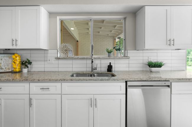 Kitchen featuring stainless steel dishwasher, a sink, and white cabinets | Image 21