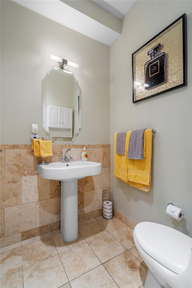Bathroom featuring tile patterned flooring, tile walls, toilet, and a wainscoted wall | Image 7
