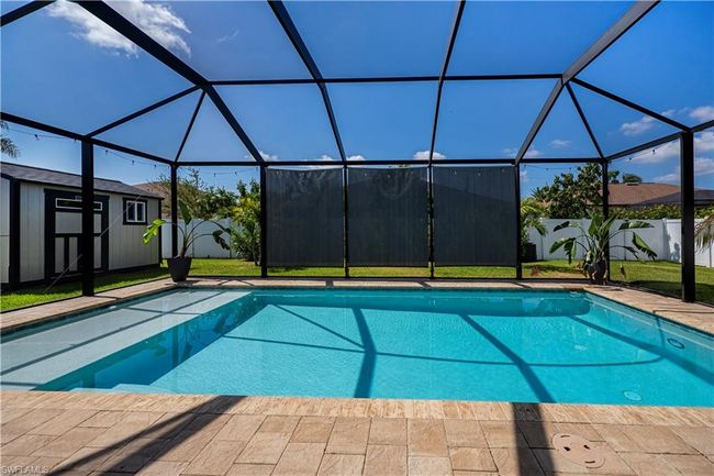 View of pool with a fenced in pool, an outdoor structure, glass enclosure, and a shed | Image 23
