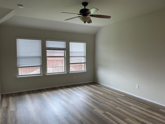 Spare room featuring wood finished floors, healthy amount of natural light, ceiling fan, and vaulted ceiling | Image 10
