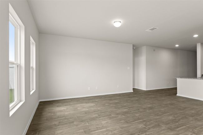 Empty room with dark wood-type flooring, visible vents, and baseboards | Image 11