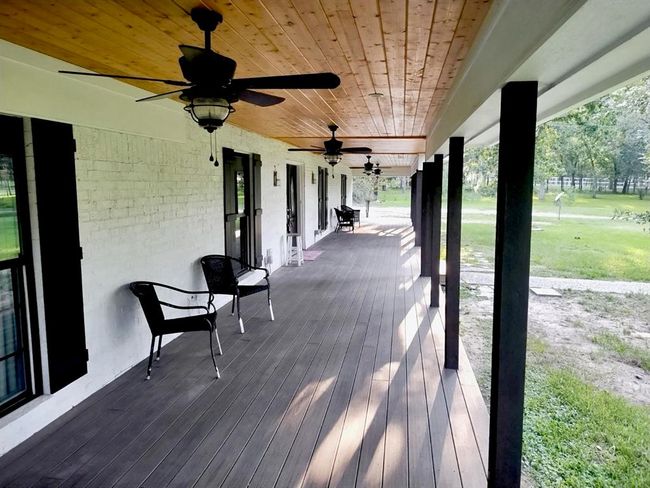 Front porch spanning entire width of home. Deck material is composite. Please note existence of four (4) fans for summer cooling while watching the deer feed in your front yard. | Image 4