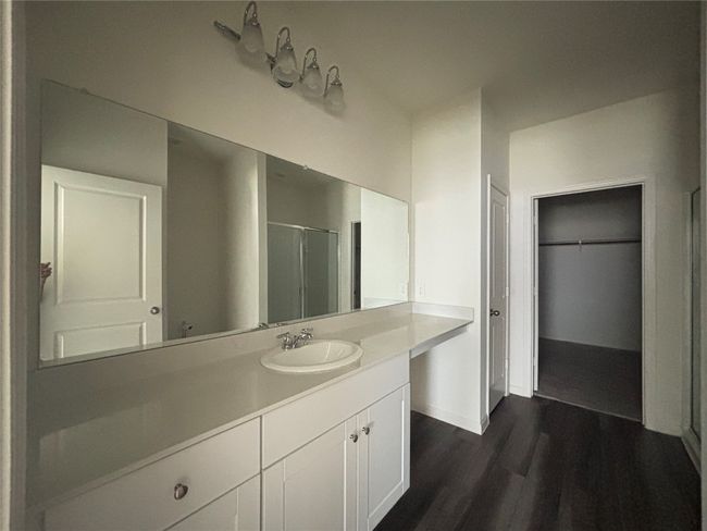 Full bath with vanity, wood finished floors, an enclosed shower, and a spacious closet | Image 12