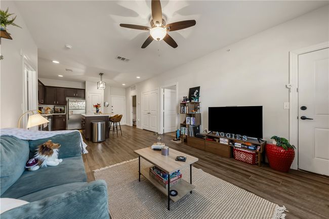 Living room with wood-type flooring and ceiling fan | Image 11