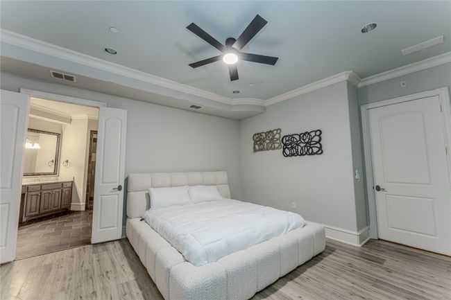 Bedroom featuring crown molding, light wood-style flooring, recessed lighting, ensuite bathroom, and a ceiling fan | Image 23
