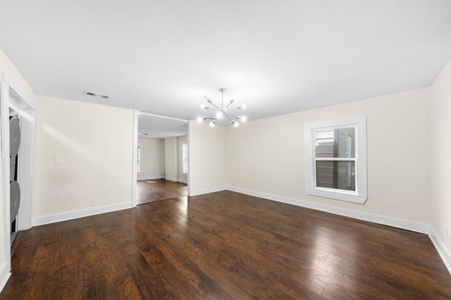 Empty room with a chandelier, hardwood / wood-style flooring, and baseboards | Image 8