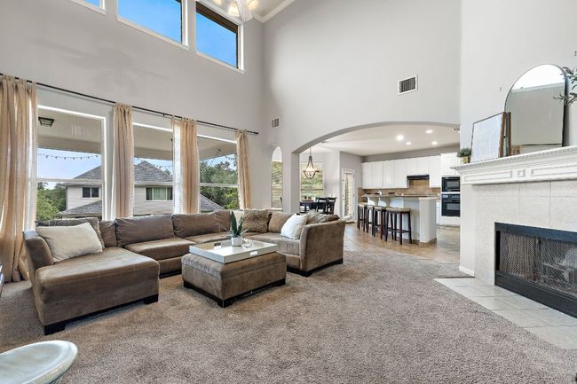 The living room is bright and open with fresh paint throughout, a gas fireplace, 2-story ceilings, and opens to the kitchen and breakfast nook. It also overlooks the beautiful backyard! | Image 13