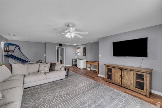Living area with baseboards, a ceiling fan, and wood finished floors | Image 30
