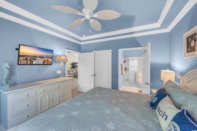 Bedroom featuring crown molding, a ceiling fan, ensuite bathroom, and a raised ceiling | Image 15