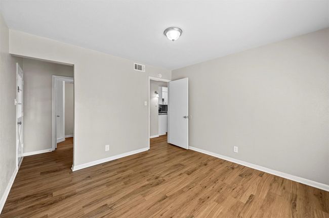 Unfurnished bedroom featuring wood finished floors and baseboards | Image 8