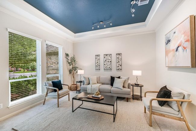 Carpeted living room with a tray ceiling and ornamental molding | Image 9