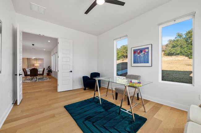 High-end interior features include impressive 8-foot doors, soaring ceilings, elegant chandeliers, recessed lighting, French doors, and a smart thermostat, creating an inviting office retreat | Image 13