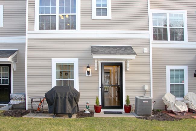 View of exterior entry featuring cooling unit and roof with shingles | Image 26