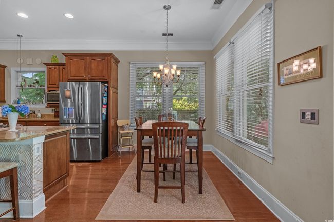 Dining area with a chandelier, dark wood-type flooring, ornamental molding, and recessed lighting | Image 16