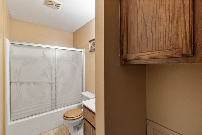 Full bath featuring vanity, combined bath / shower with glass door, and a textured wall | Image 24
