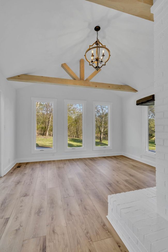 Sun room off of the kitchen with tall ceilings, wood beams, and casement windows. | Image 17