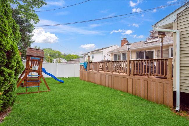 View of yard featuring a playground and a wooden deck | Image 24