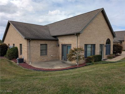 Rear view of house with central AC unit, a yard, and a patio | Image 3