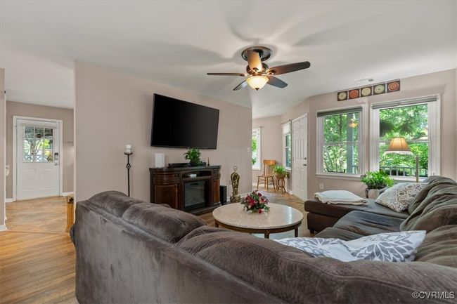Living room featuring a ceiling fan, plenty of natural light, baseboards, and light wood-type flooring | Image 11