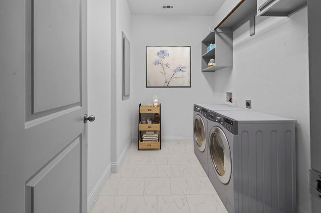 Laundry room with washing machine and clothes dryer, visible vents, baseboards, marble finish floor, and laundry area | Image 9