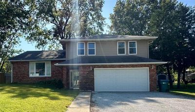 View of front facade with a front lawn and a garage | Image 1