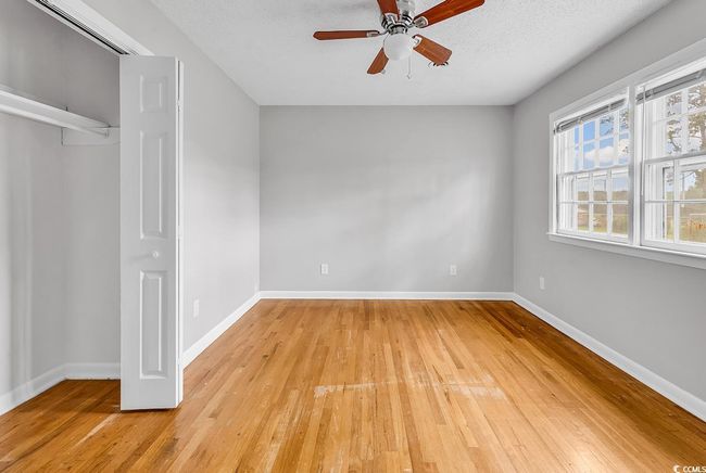 Unfurnished bedroom with light wood-style floors, a closet, and a ceiling fan | Image 26