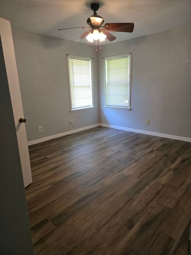 Unfurnished room featuring a ceiling fan and dark wood-type flooring | Image 20