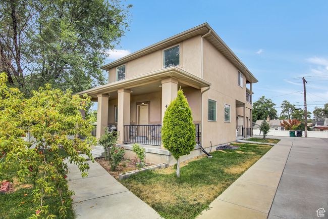 View of front of property with covered porch, stucco siding, and a front yard | Image 4