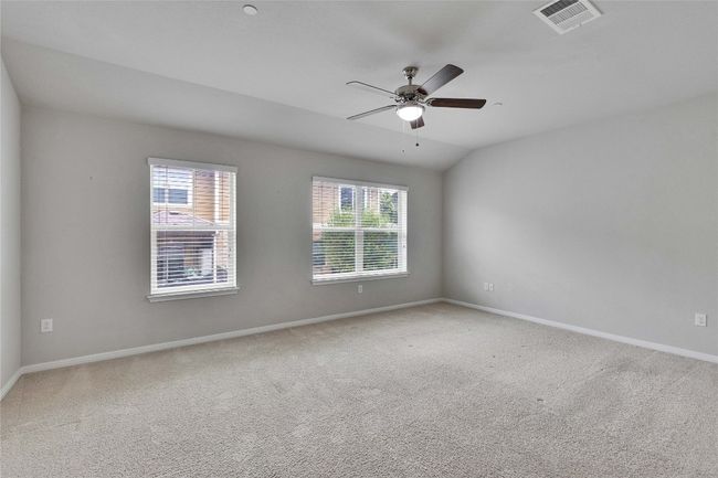 A secondary master bedroom with a wall of windows that over looks the back yard. | Image 15