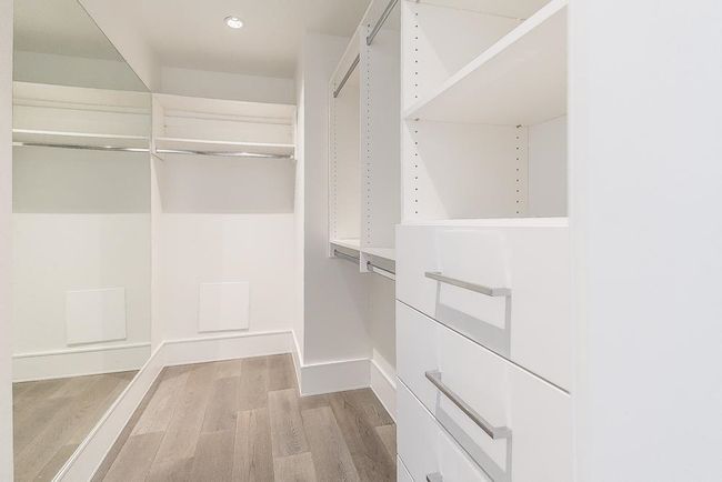 Walk in closet with light wood-style floors | Image 22