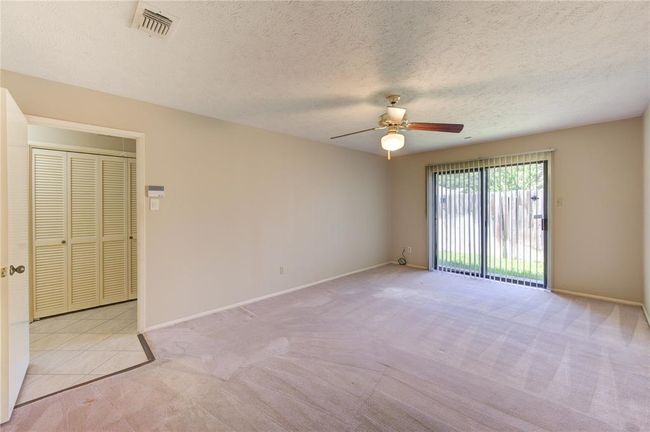 Spacious primary bedroom with plush carpet. | Image 15