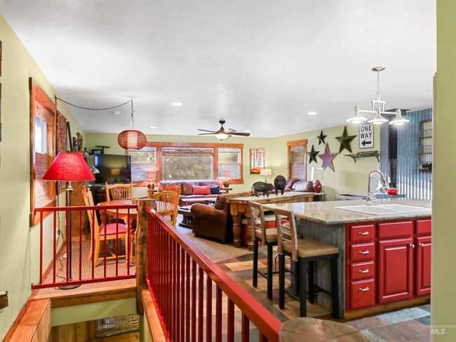 Kitchen with open floor plan, a ceiling fan, decorative light fixtures, reddish brown cabinets, and recessed lighting | Image 28