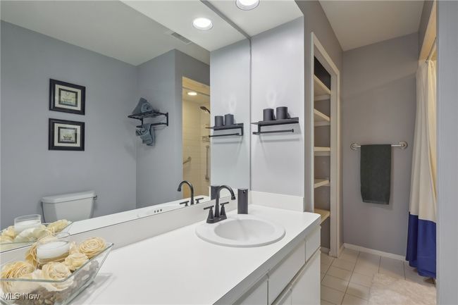 Full bathroom featuring a shower, visible vents, toilet, vanity, and tile patterned flooring | Image 29
