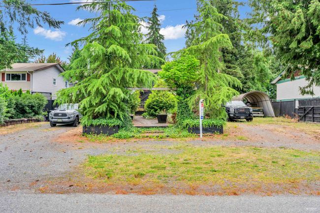 View of yard with a detached carport, driveway, and fence | Image 38