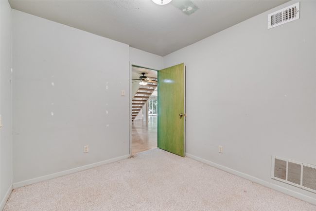 Empty room with carpet flooring, baseboards, a ceiling fan, and stairway | Image 31