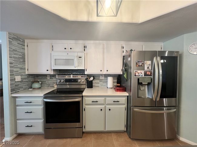 Kitchen featuring appliances with stainless steel finishes, decorative backsplash, and light countertops | Image 18