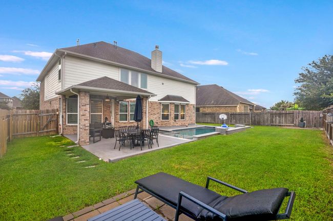 This photo showcases a spectacular modern rectangular pool and Spa, a covered patio making this an inviting outdoor space. | Image 42