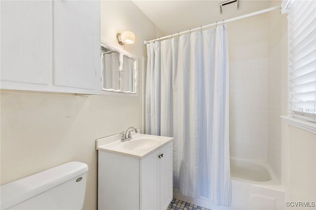 Bathroom featuring visible vents, shower / tub combo, toilet, and vanity | Image 23