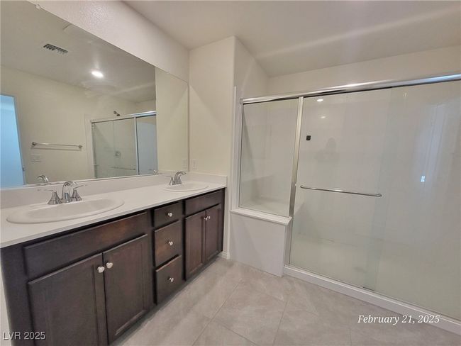 Bathroom with double vanity, a stall shower, a sink, and visible vents | Image 17