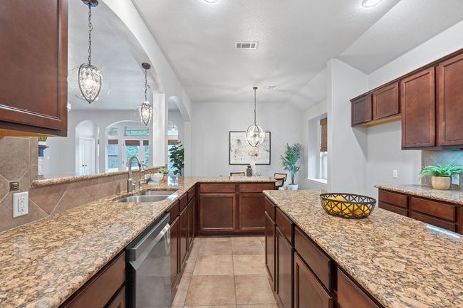 Kitchen with stainless steel appliances, center island, arched walkways, backsplash, and a chandelier | Image 14