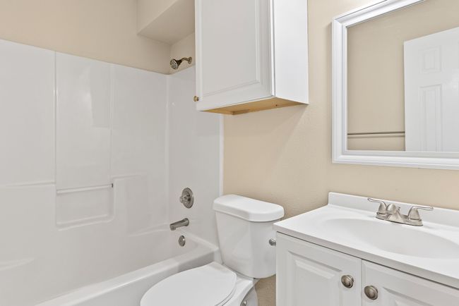 Hall bathroom featuring shower combination, vanity, and toilet | Image 19