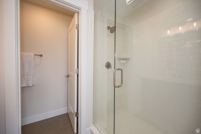 Bathroom with a stall shower, tile patterned flooring, and baseboards | Image 31