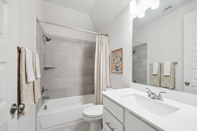 The spacious bathrooms are well-appointed with understated elegance, featuring crisp white countertops and classic white cabinetry that create a clean, timeless aesthetic. | Image 24