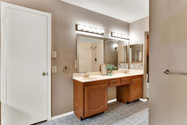 Full bathroom with double vanity, a tile shower, and tile patterned floors | Image 19